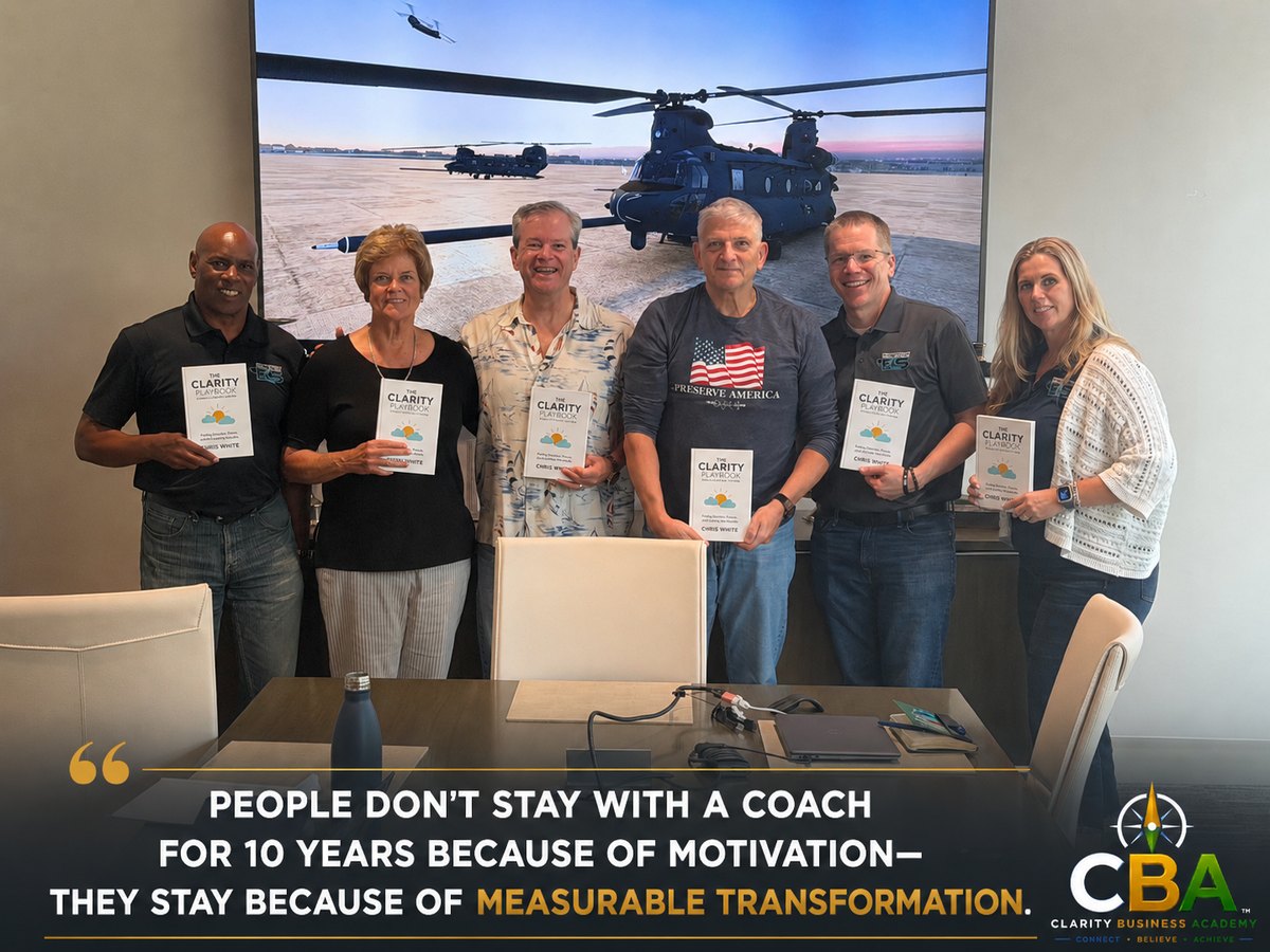 A client leadership team holding copies of The Clarity Playbook